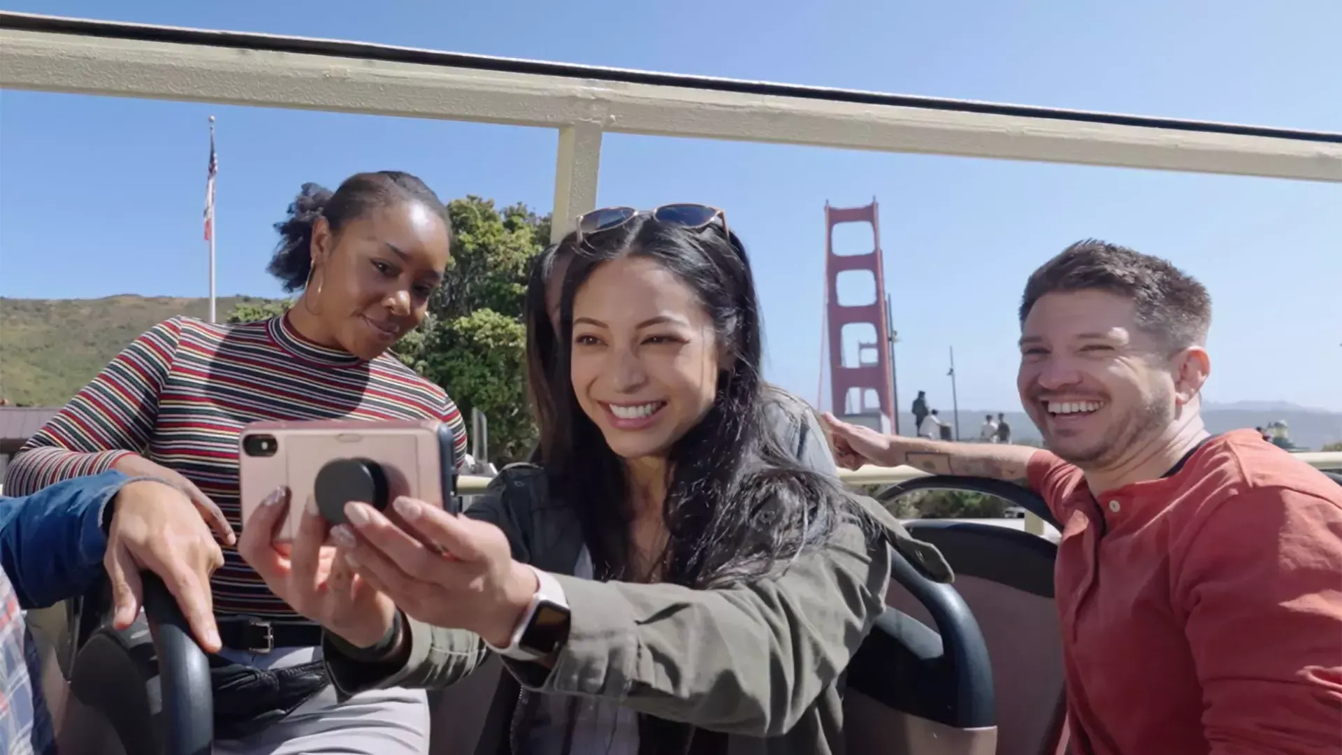 A group of visitors take a selfie on a bus tour near the Golden Gate Bridge. San Francisco, CA.